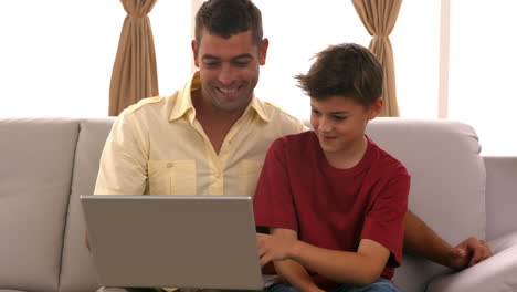 Vater-Und-Sohn-Mit-Laptop-Auf-Der-Couch