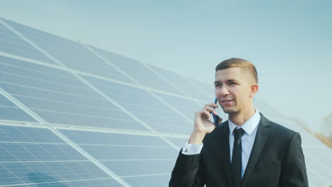 Erfolgreicher-Geschäftsmann,-Der-Vor-Dem-Hintergrund-Eines-Solarkraftwerks-Telefoniert
