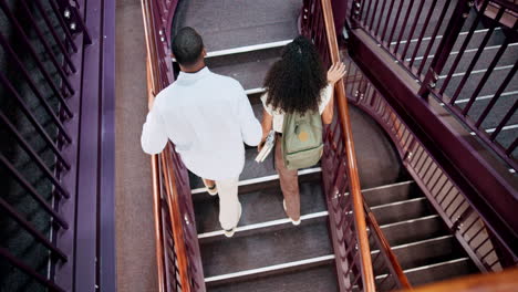 students walking up spiral stairs in library