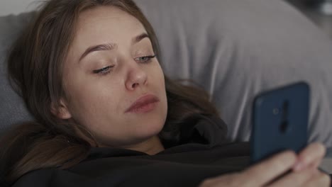 caucasian woman relaxing on the couch and using mobile phone.