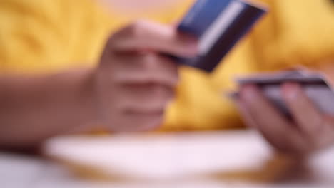 close-up of an individual who is choosing a credit card and handing one to another person on the other side of the frame