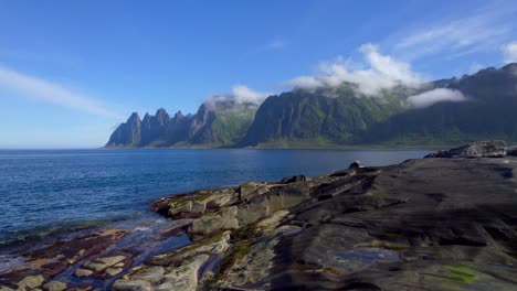 aerial drone shot following someone walking then running on the rocks near the famous tungeneset senja island viewing area along the scenic route view to devil's jaw