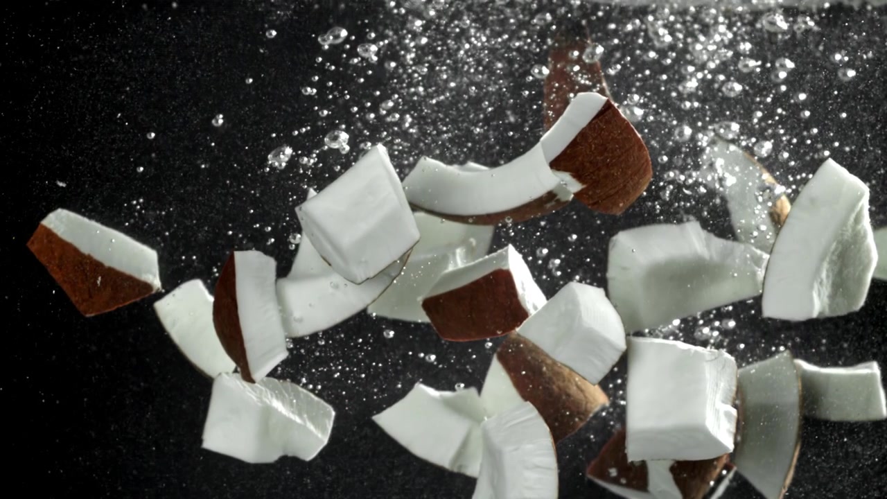 Pezzi di cocco fresco galleggianti in acqua con bolle