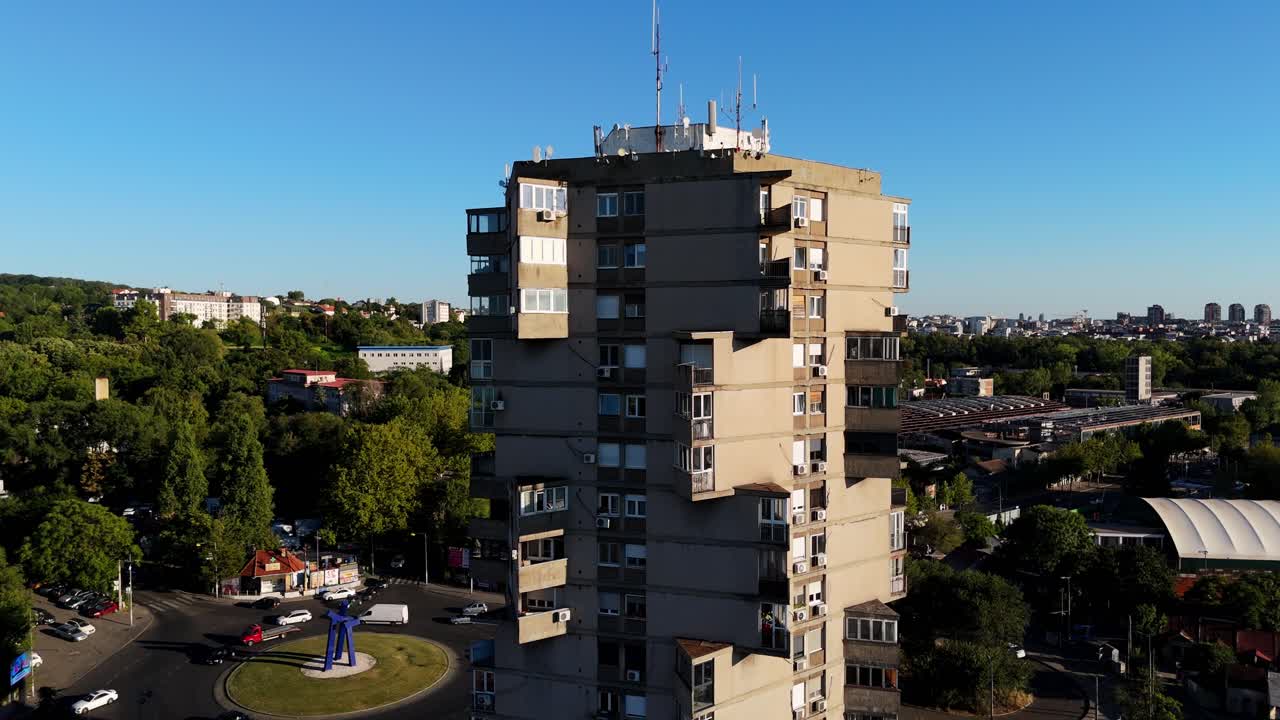 Close-up drone view of Karaburma brutalist building in Belgrade, Serbia bold architectural lines and cantilevered balconies captured against the clean blue sky