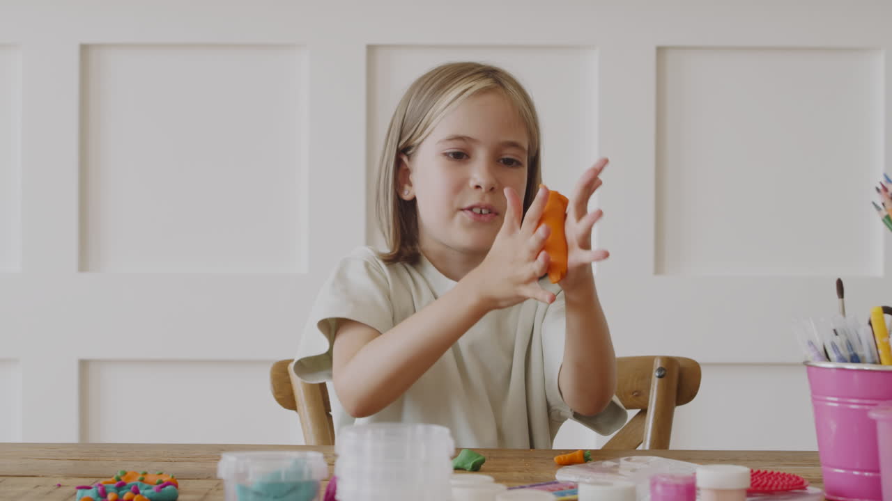 A Little Blonde Girl Putting Clay Under Her Nose As If It Were A Moustache