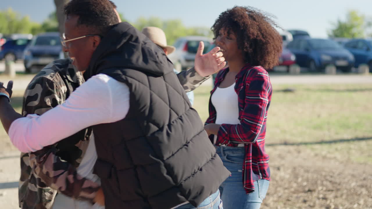 Friends Reuniting with Hugs at an Outdoor Gathering