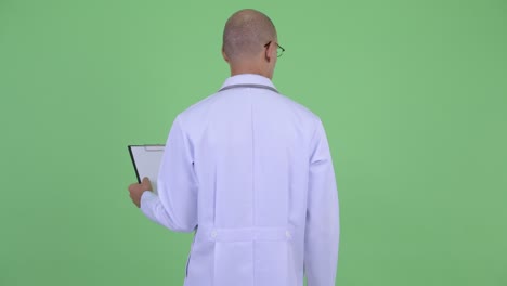 handsome bald multi ethnic man doctor with clipboard