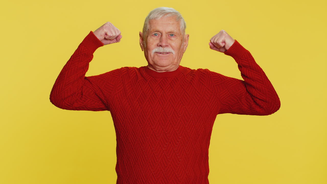 Senior man looking confident showing biceps feeling power strength to fight for rights success win