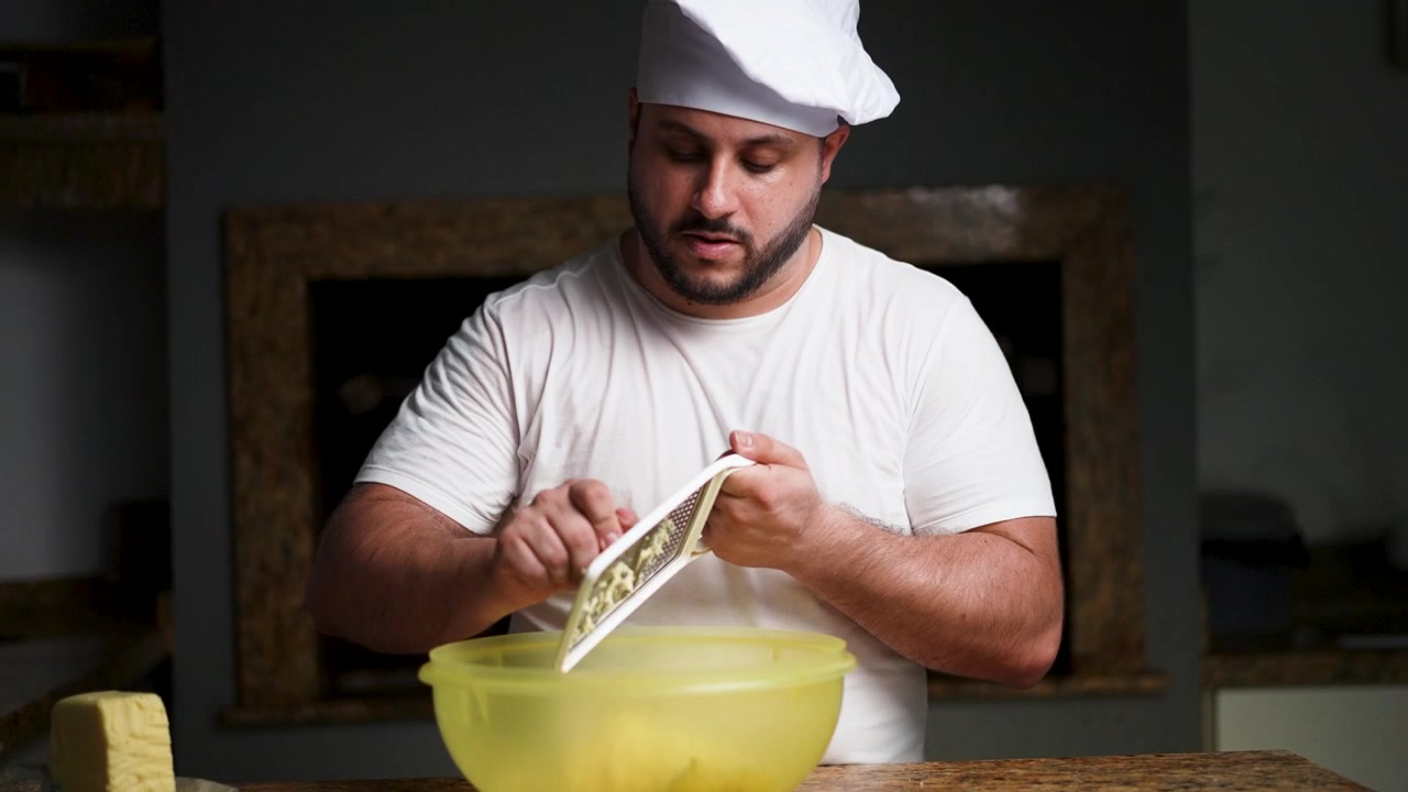 Un'inquadratura media di uno chef che grattugia il formaggio, ripreso dalla vita in su. La scena evidenzia l'esperienza culinaria e la preparazione di ingredienti freschi