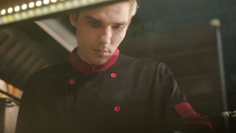 chef preparing pizza toppings in a restaurant kitchen