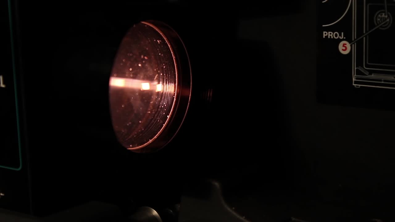 Close-up of a Vintage Projector Lens with Flickering Red Light