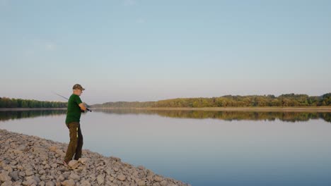 senior adult men casting fishing rod along the river coast