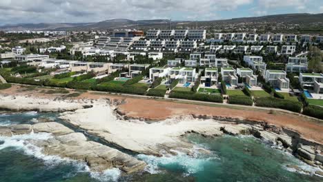 a cinematic drone captures white homes lined side by side, each featuring a private outdoor swimming pool, creating a serene, stylish, and cohesive seaside community.