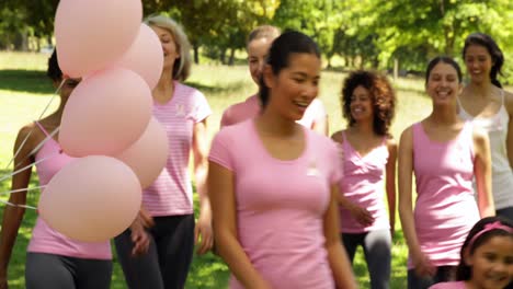 mujeres felices dando un paseo para concienciar sobre el cáncer de mama en el parque