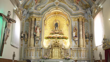 ornate baroque church altar with statues, gold accents, and floral decor