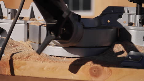 Slider-Shot-of-Miter-Saw-on-Wood-with-Glasses-and-Sawdust