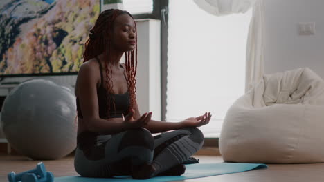 flexible black woman stretching muscle practicing gymnastics in morning