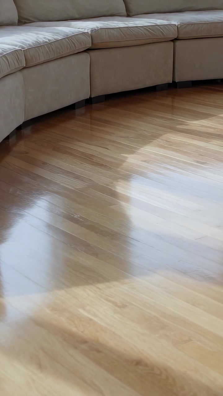 Vídeo vertical: Câmera panorâmica mostrando sofá modular na sala de estar, revelando o reflexo do chão.