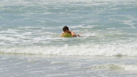 male surfer surfing with surfboard in the sea at beach 4k