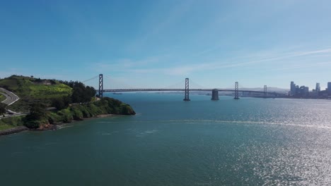 drone shot flying towards the oakland bridge and downtown san francisco midday