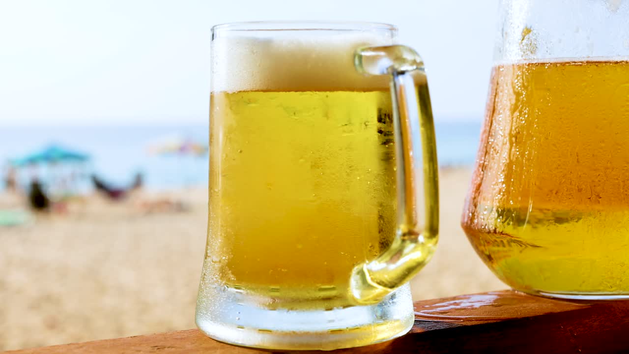 dos vasos de cerveza en una playa soleada