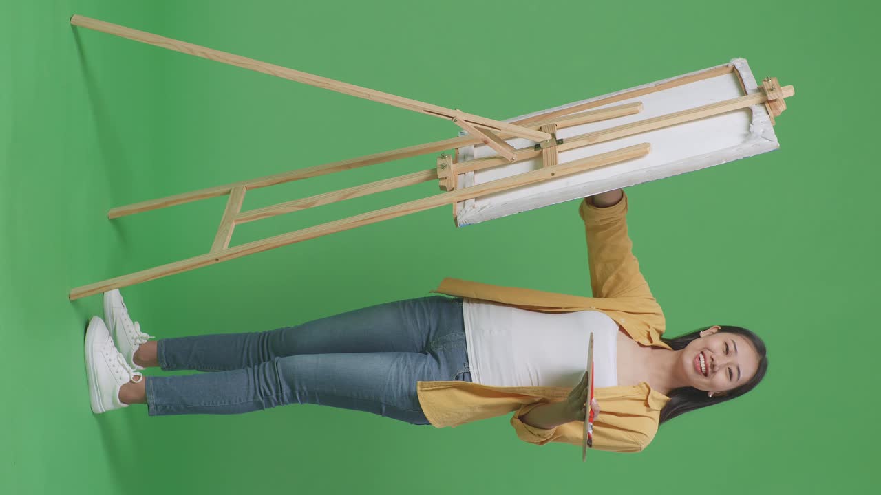 페인팅 용품 을 들고 포즈 를 취하는 여성 예술가