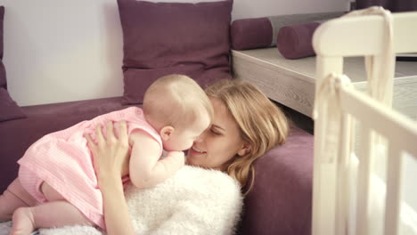 young mother kissing baby at home. love and happiness concept