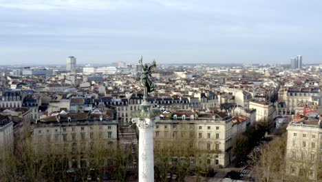 Angel-of-liberty-Girondins-monument-in-Bordeaux,-France-with-city-panoramic,-Aerial-circling-shot