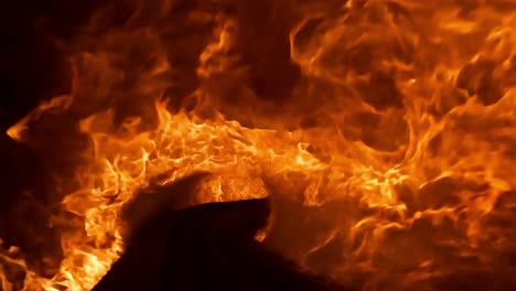 conveyor belt transporting an indistinguishable object passes through an industrial oven, exposed to intense heat and flames