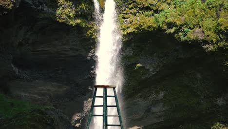 Hombre-Tocando-La-Guitarra-Frente-A-Una-Hermosa-Cascada-En-Islandia