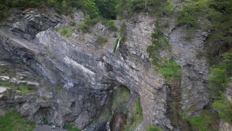 revealing beautiful waterfall on rocky slope of mountain, inside green forest in albania