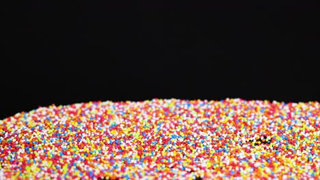 vibrant sprinkles cascade onto a dark background