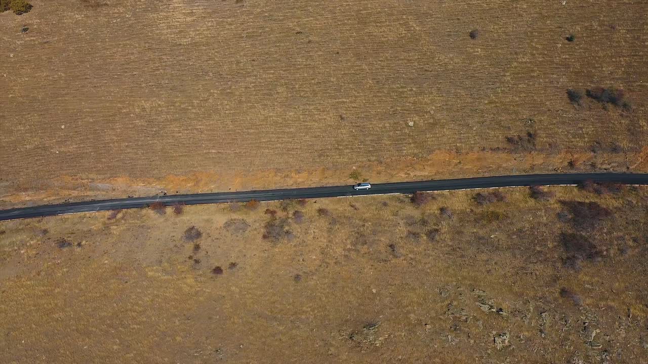 Auto in transito su una strada rurale aperta, ripresa con drone