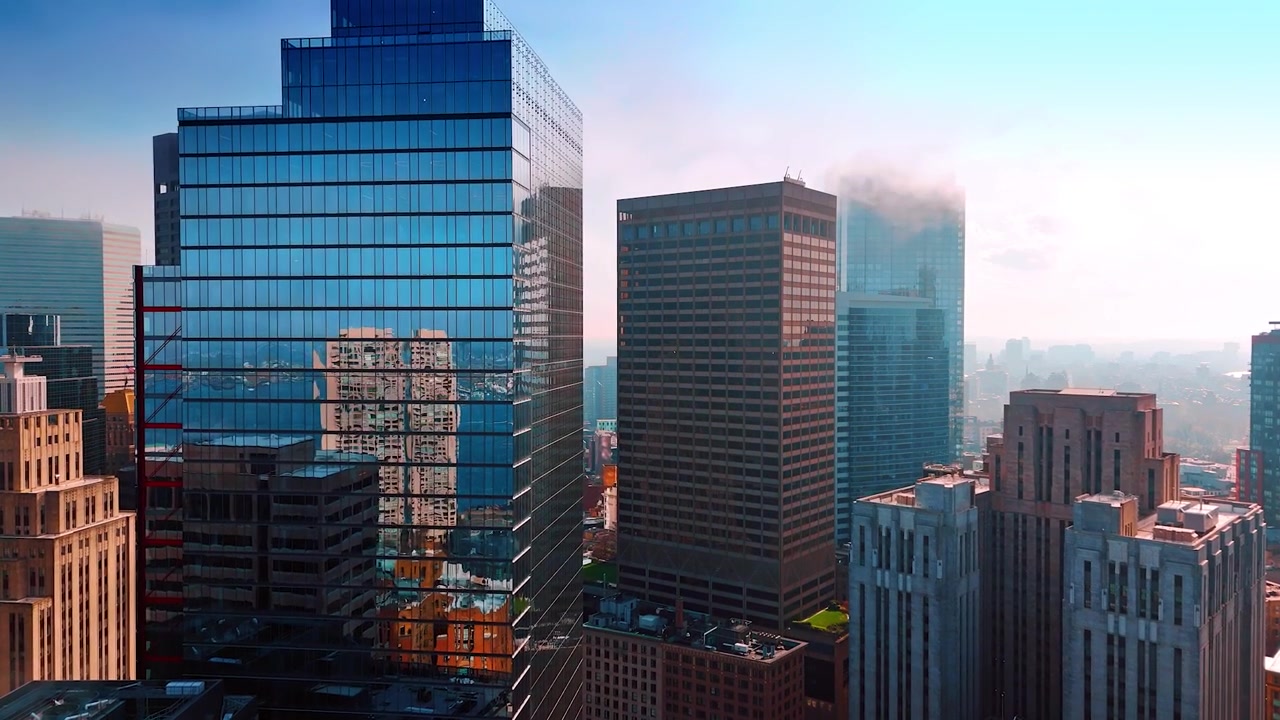 Voando para mais perto dos enormes edifícios onde a paisagem urbana se reflete. Fumaça sobe acima dos topos das torres mais altas de Boston, Massachusetts, EUA