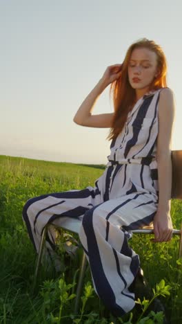 woman in a striped jumpsuit in a field at sunset