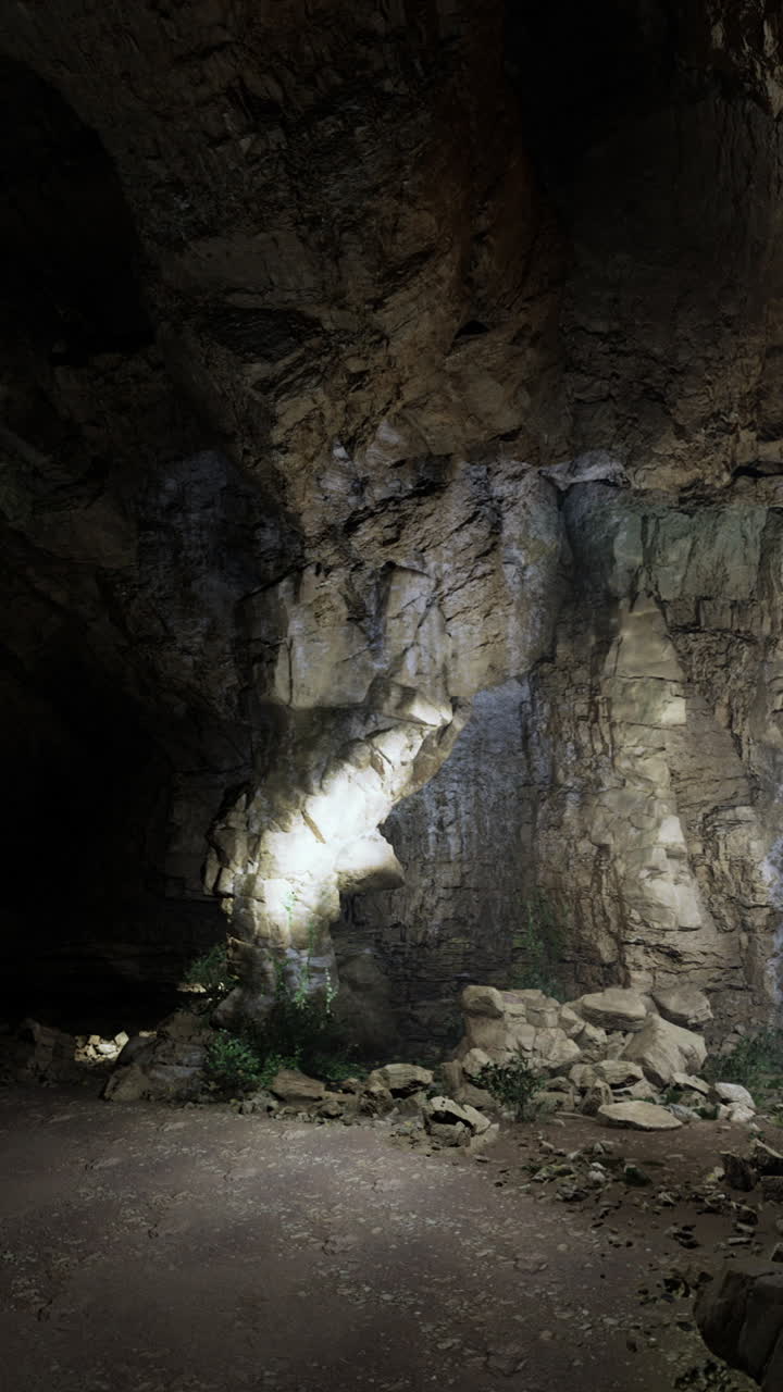 Exploring a dimly lit cave with textured rock formations and shadows