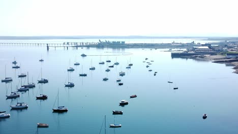 sunny holyhead harbour rompeolas yates marítimos acoplados a lo largo de la tranquila costa azul transparente vista aérea de sobrevuelo
