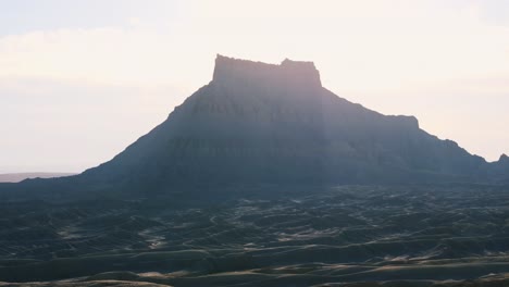 Sonnenbeschienenen-Factory-Butte-Und-Seine-Karge-Landschaft-In-Wayne-County,-Utah