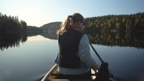 woman paddling canoe boat on beautiful lake in autumn, rear view slow motion-1