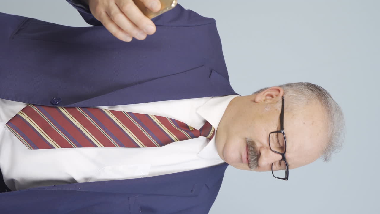 vídeo vertical de un viejo hombre de negocios recibe malas noticias y se enoja.