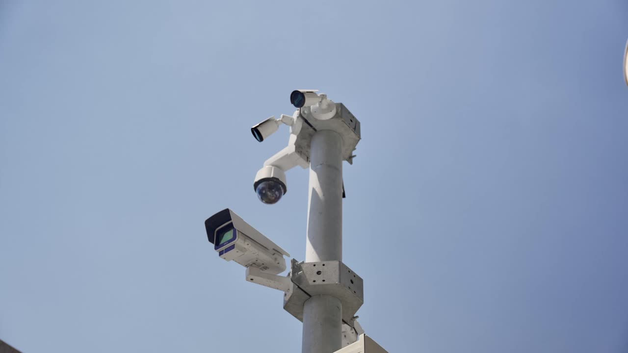 Telecamere di sicurezza in cima a un palo in città che sorvegliano civili o siti importanti, strade o edifici. Postazione esterna con tecnologia di spionaggio. Grande fratello. Edificio governativo