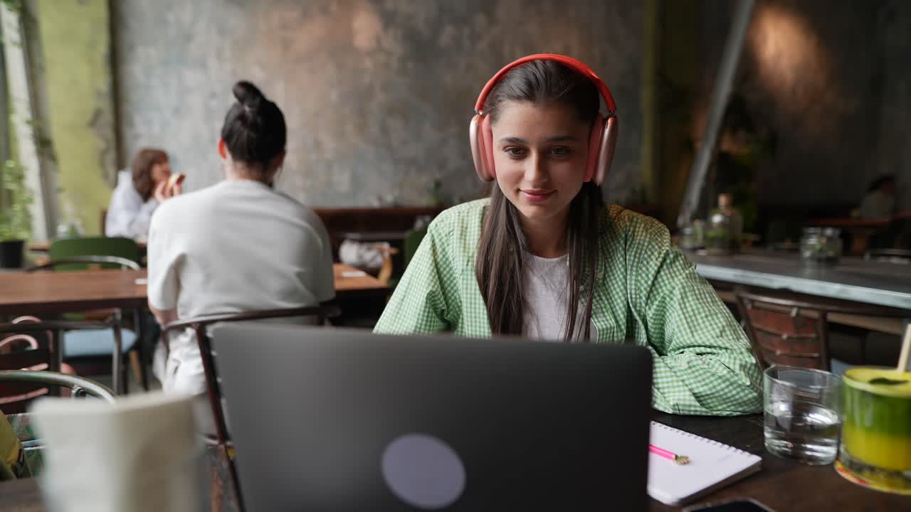 mujer trabajando en una computadora portátil en un café