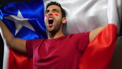 un chileño celebrando con la bandera de chile.