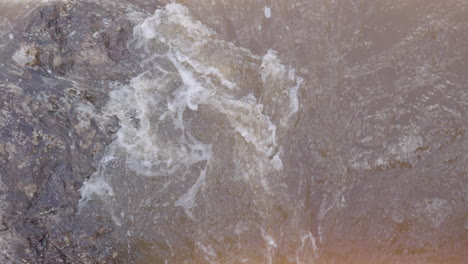 Close-Up-of-River-Rapids-Over-Stone-with-Foam-Patterns