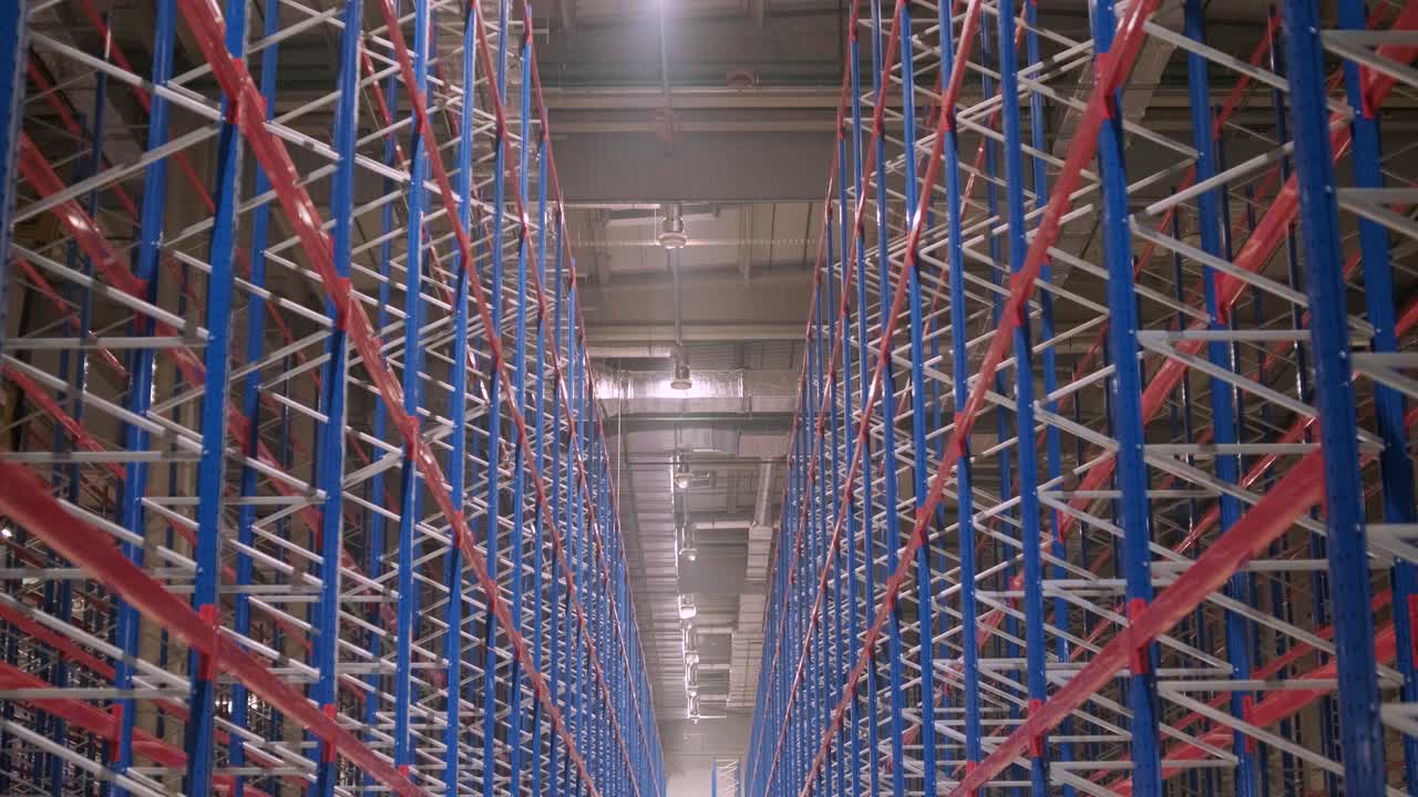 gran y moderno almacén en construcción, con estanterías metálicas y otros equipos industriales.