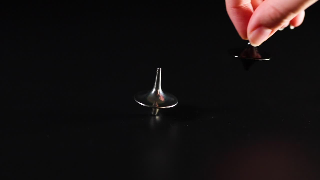 рука, вращающая верхушку на поверхности