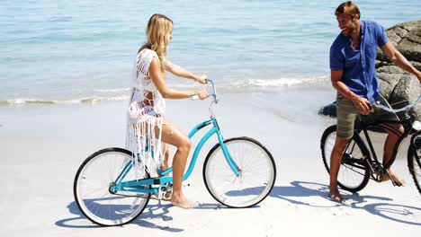 Couple-riding-bicycle-at-beach