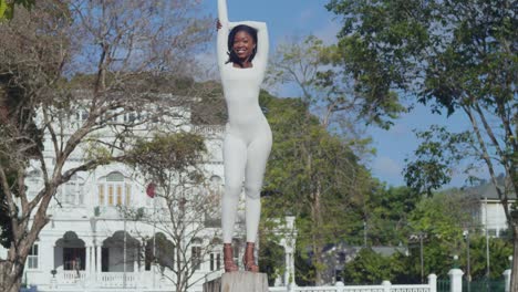 A-young-girl-in-a-white-bodysuit-relishes-a-day-in-the-city-with-Whitehall-castle-behind-her