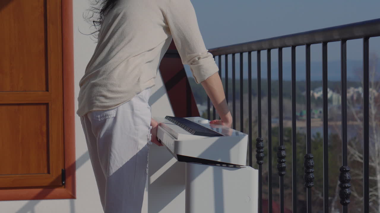 Woman playing portable piano on a balcony