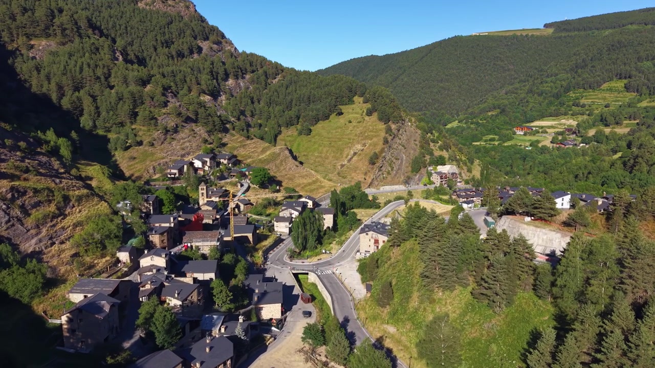 Andorra'daki Pal köyü, berrak mavi gökyüzünün altında, çam ormanları ve kayalık yamaçlarla çevrili, kıvrımlı yolları ve taş binaları olan bir dağ vadisine kurulmuştur.